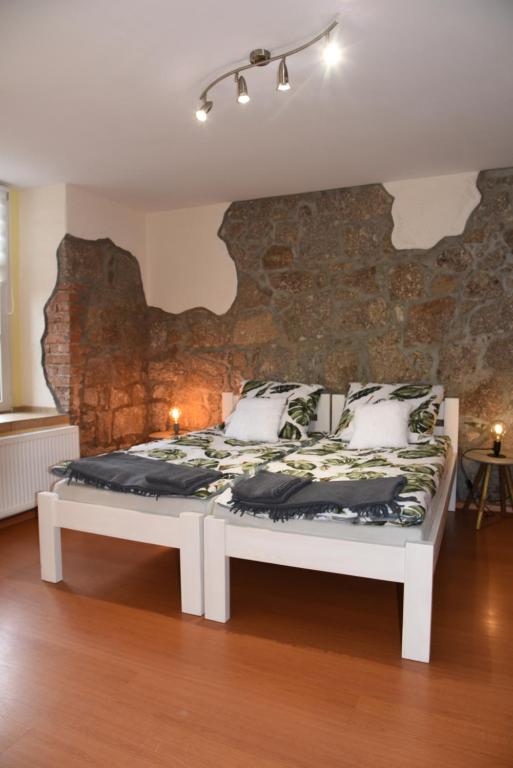 カルパチにあるKarkonoska 12の石壁の客室の白いベッド1台