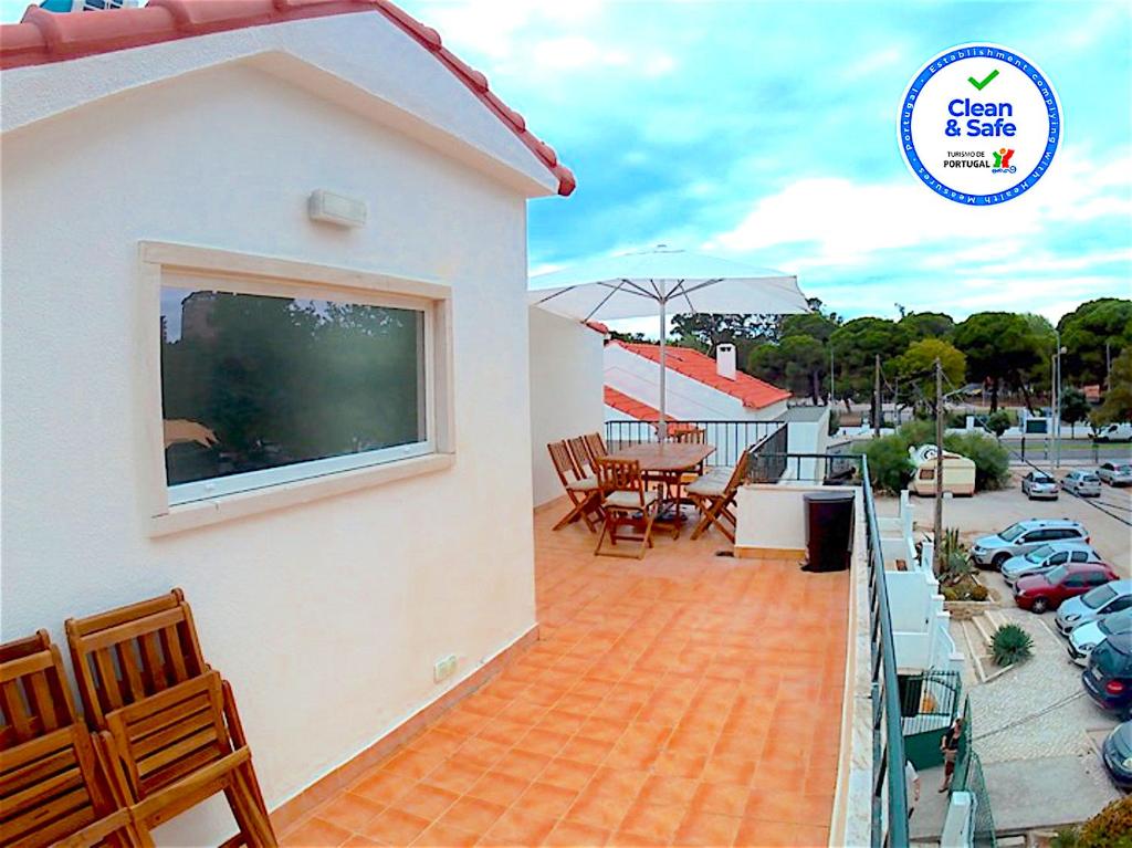 a balcony of a house with a table and chairs at Apartment near the beach with big terrace in Setúbal