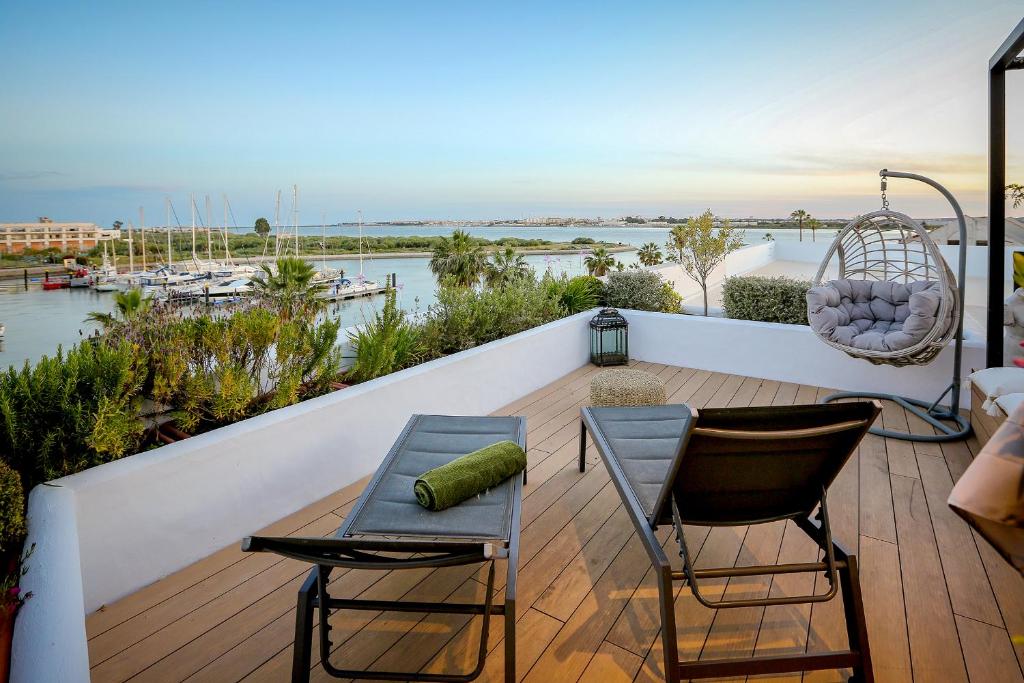 balcón con mesa, sillas y vistas al agua en DONDE DUERME EL GUADIANA, en Ayamonte