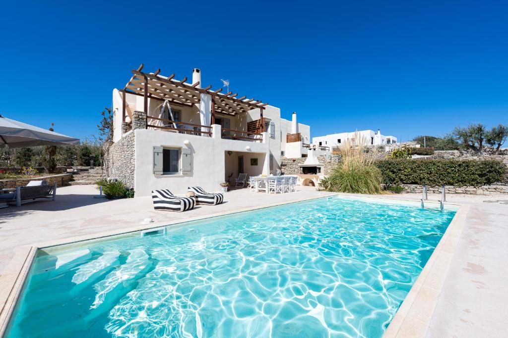 a villa with a swimming pool in front of a house at Parasporos Villa - Private Pool - Beach Access in Parasporos