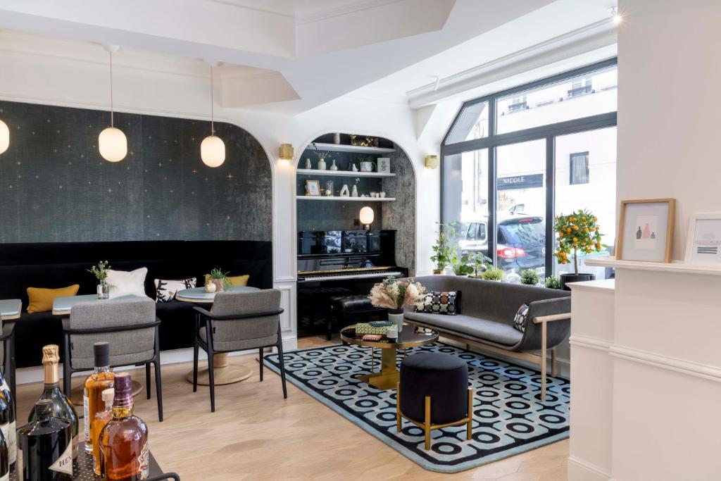 a living room with a couch and chairs and a table at Hotel Louvre Montana in Paris