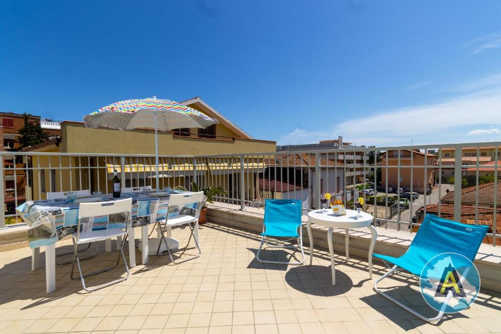 patio con sedie blu, tavoli e ombrellone di Casa di Manuela a Silvi Marina