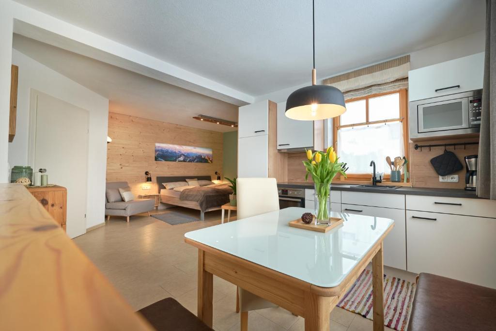 a kitchen and living room with a vase of flowers on a table at Appartement Eckwald Altenmarkt-Zauchensee in Altenmarkt im Pongau