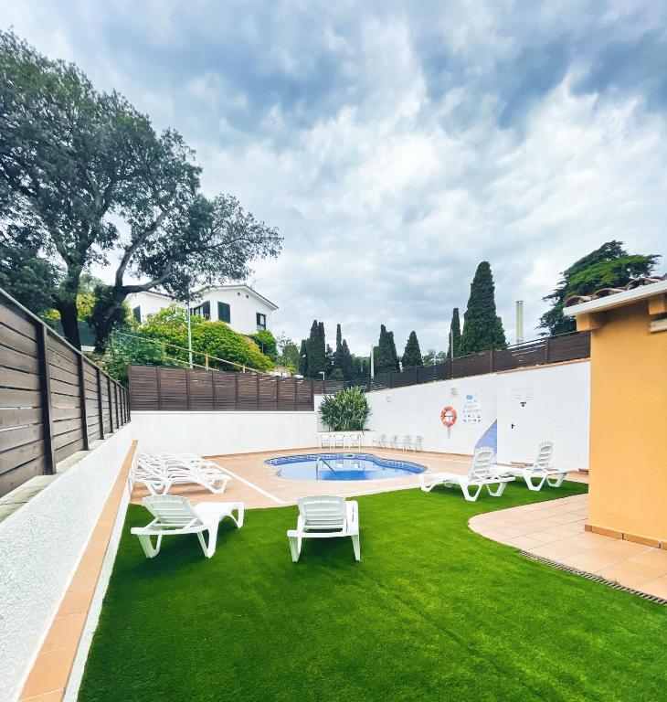 a yard with chairs and a swimming pool at Hotel Turissa in Tossa de Mar