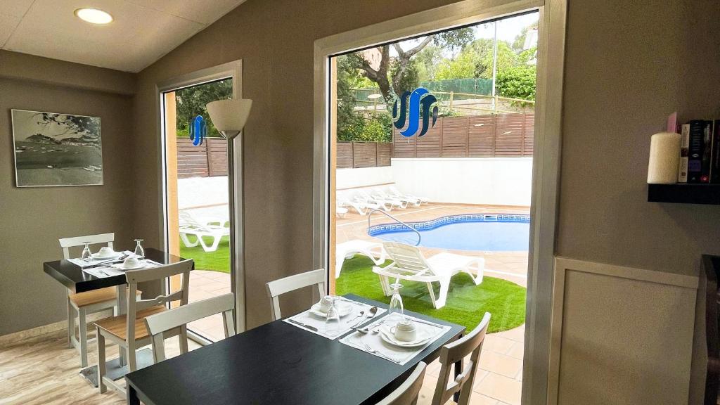 a dining room with a table and chairs and a pool at Hotel Turissa in Tossa de Mar
