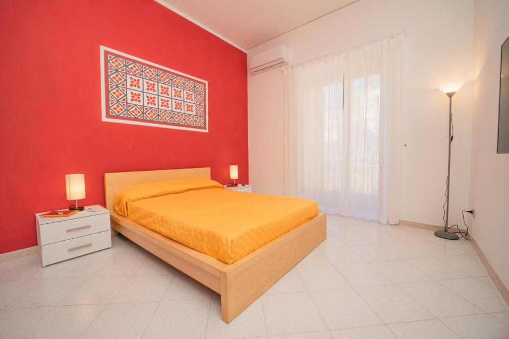 una camera con letto e parete rossa di Ada's House ad Atrani