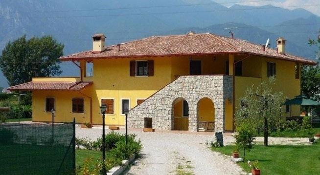 a large yellow house with a roof at Agritur Maso Fontane in Arco
