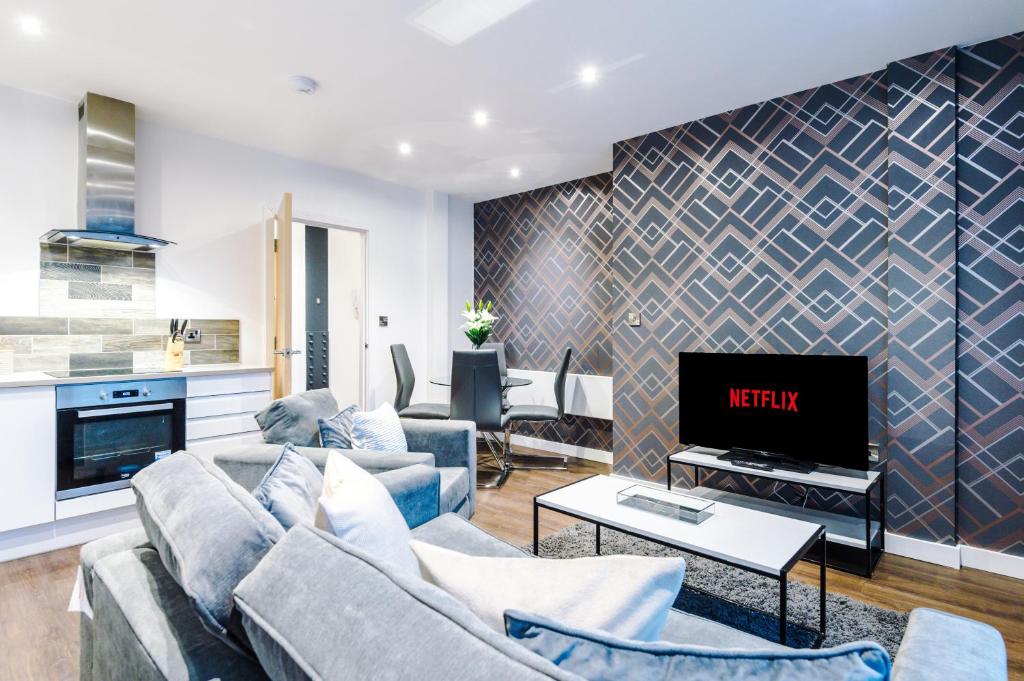 sala de estar con sofá y TV en The Popworks 2 Bedroom Apartment - MCR Dens en Mánchester