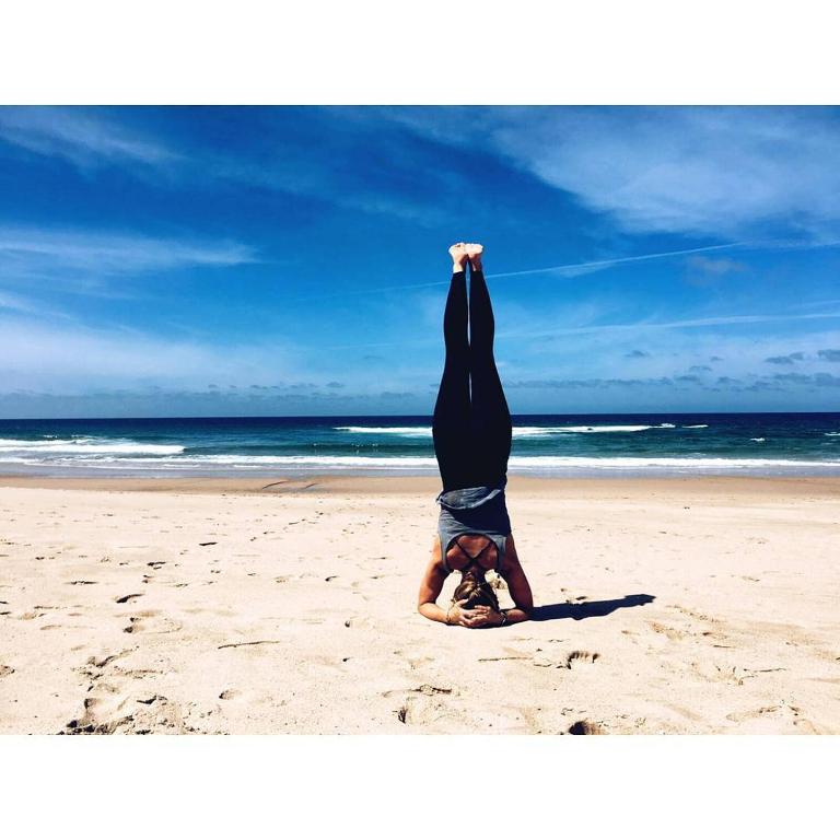 a person doing a handstand on the beach at Golden Halcyon - Ericeira Villas in Ericeira