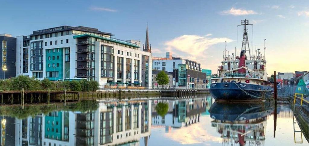 eine Stadt mit einem Boot im Wasser mit Gebäuden in der Unterkunft D Hotel in Drogheda