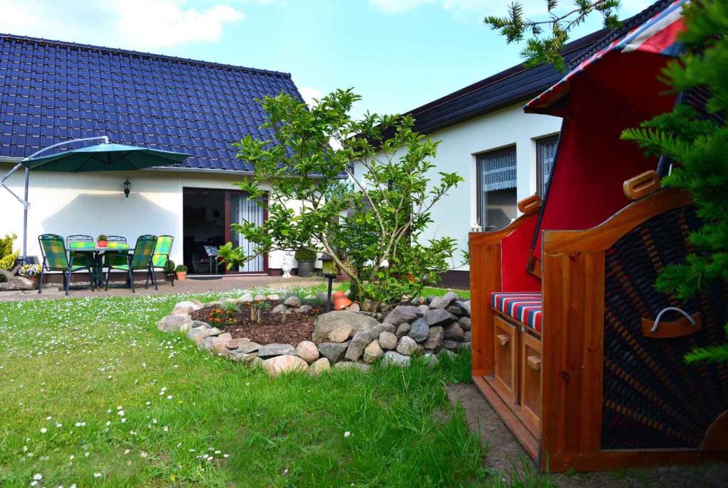einen Garten mit einer Bank und einem Baum im Hof in der Unterkunft Apartment Bergen auf Rugen 1 in Mölln-Medow