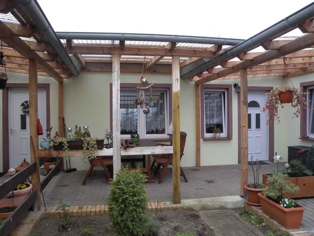 a patio with a wooden pergola and a table at Apartment Kamminke 2 in Kamminke