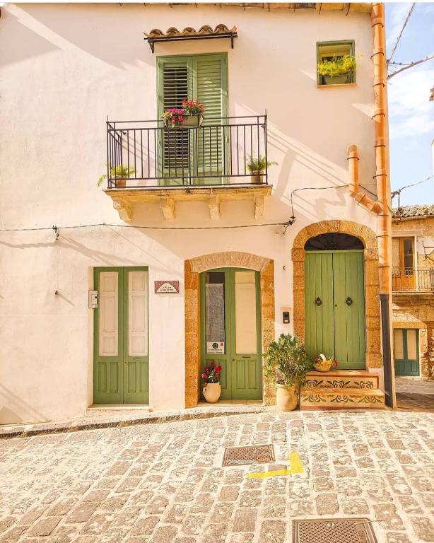 budynek z zielonymi drzwiami i balkonem w obiekcie Le Stanze dell'Emiro w mieście Sambuca di Sicilia