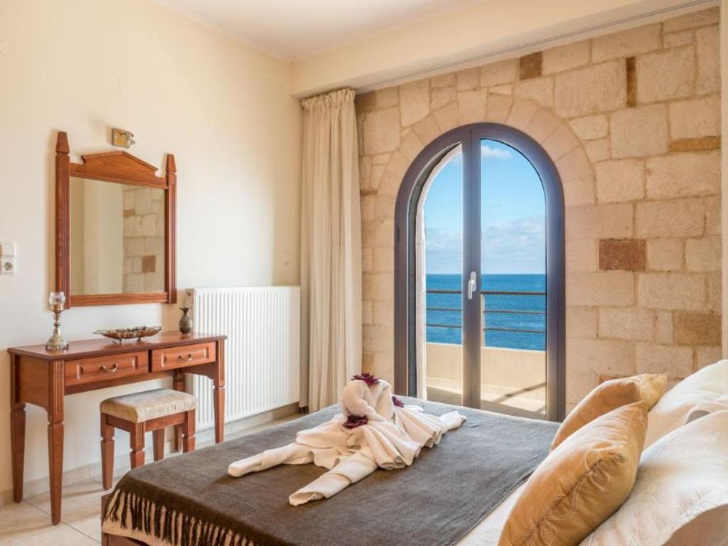 a bedroom with a bed with a view of the ocean at Xristinas Seaside Apartments in Kolymvari