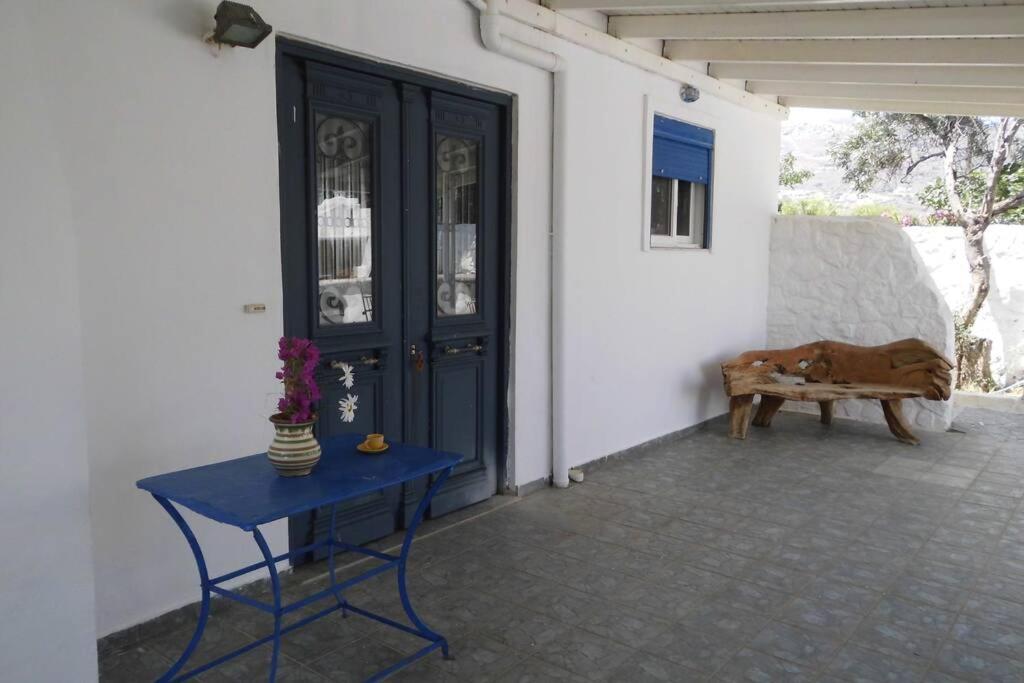 a blue table in front of a door with a bench at Παραλια Γαυρίου in Gavrion