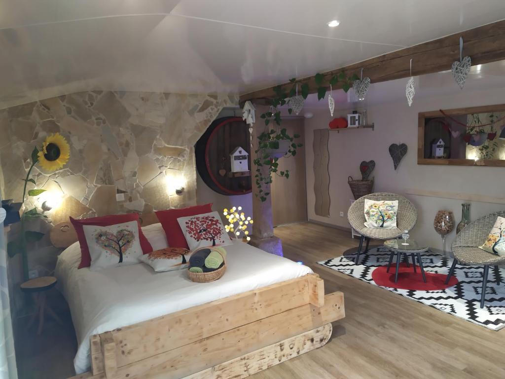 1 dormitorio con 1 cama y sillas en una habitación en Le p'tit coin de chez nous, en Dambach-la-Ville