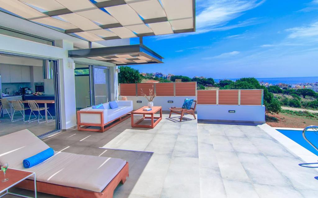 a patio with a couch and a table and chairs at Amphitheatre Suites in Palaiochóra