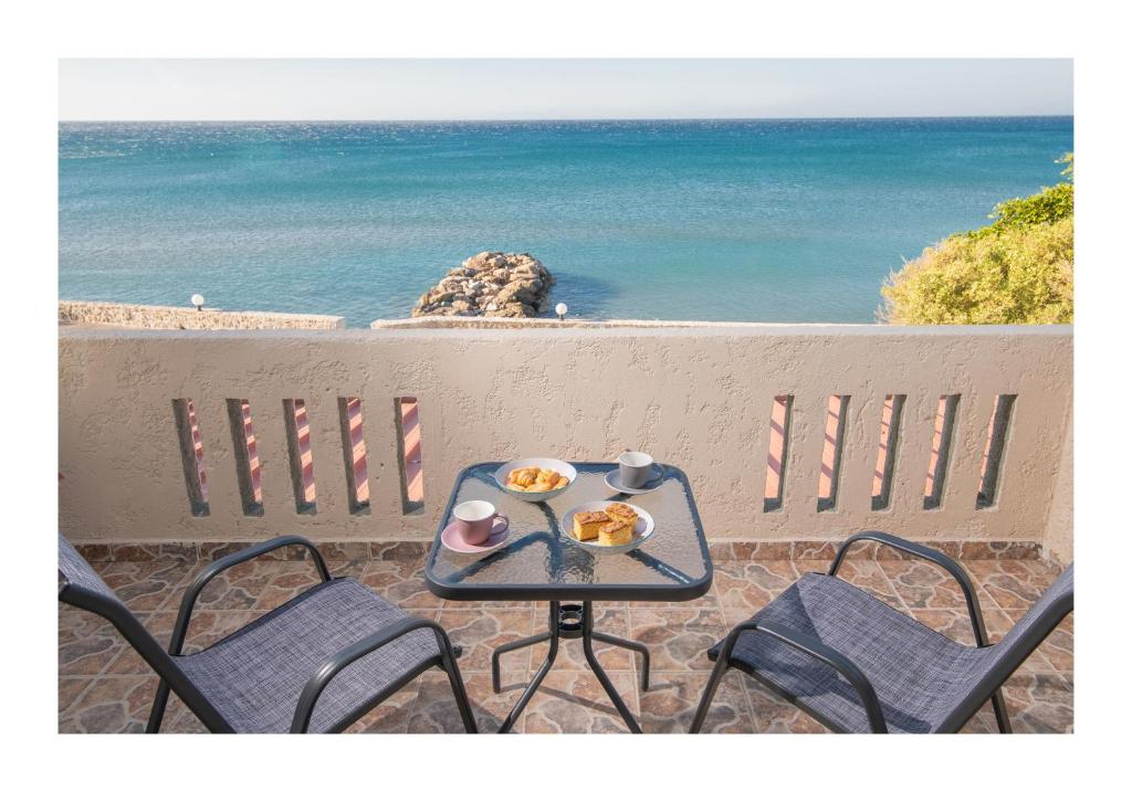 a table with a tray of food on a balcony overlooking the ocean at Kastri Mare Sea View Residences by Estia in Keratokampos