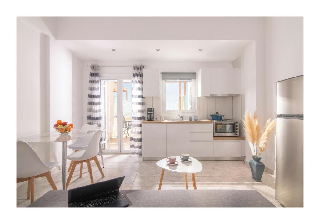 a kitchen and living room with a table and chairs at Kastri Mare Sea View Residences by Estia in Keratokampos
