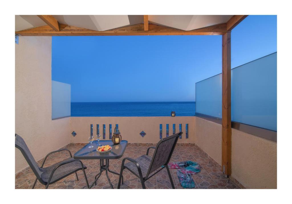 a patio with a table and chairs and the ocean at Kastri Mare Sea View Residences by Estia in Keratokampos