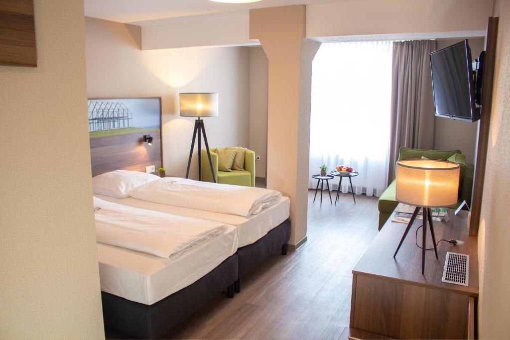 ein Hotelzimmer mit einem Bett und einem TV in der Unterkunft Hotel Dampfmühle in Neukirchen-Vluyn
