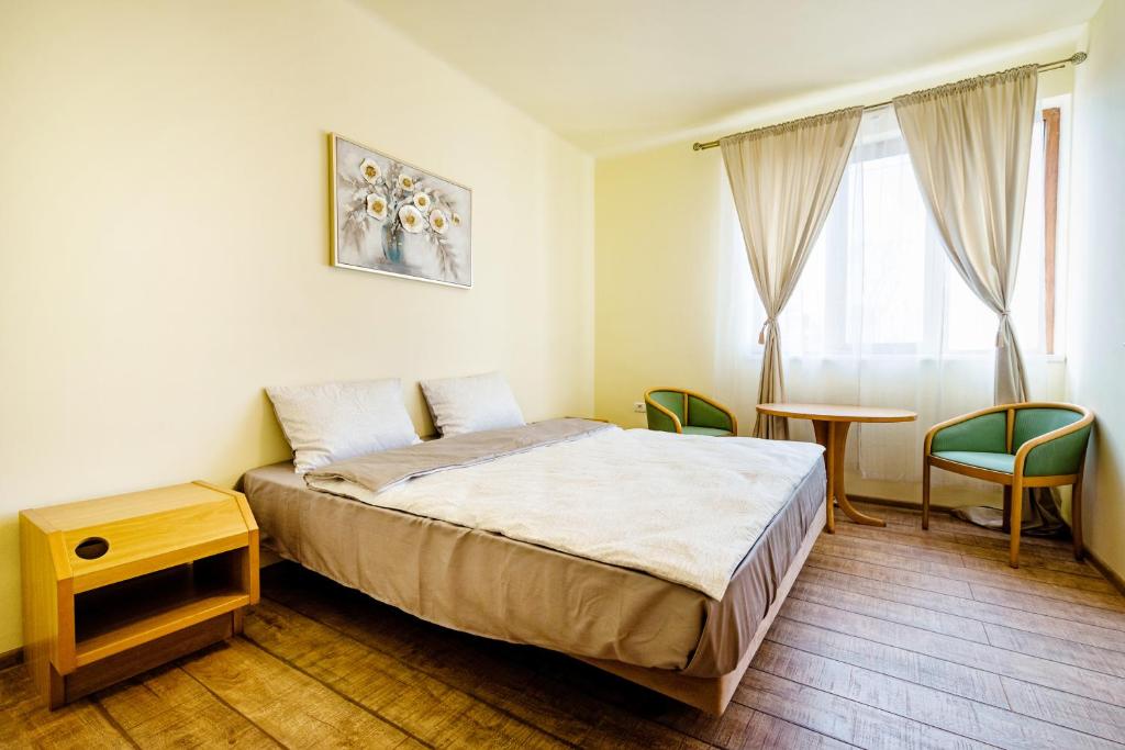 1 dormitorio con 1 cama, mesa y sillas en Casa MB, en Ghioroc