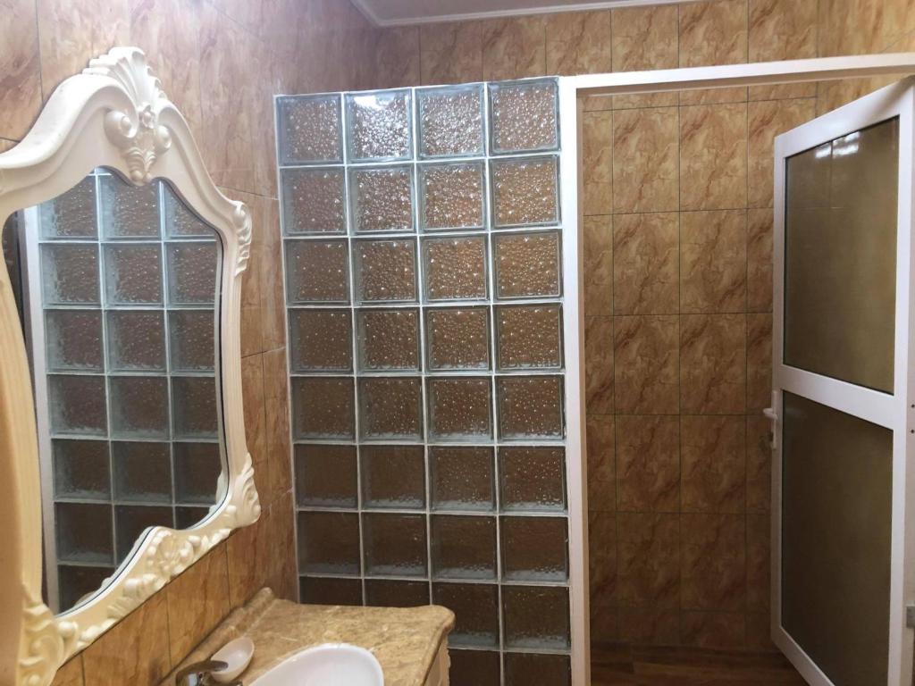 a bathroom with a shower with a mirror and a sink at Mirella Villa Ocean View Villa in Praslin