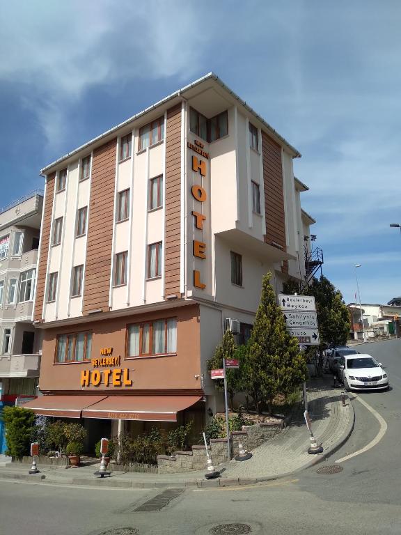 a hotel building with a hotel sign on a street at NEW BEYLERBEYİ HOTEL in Istanbul