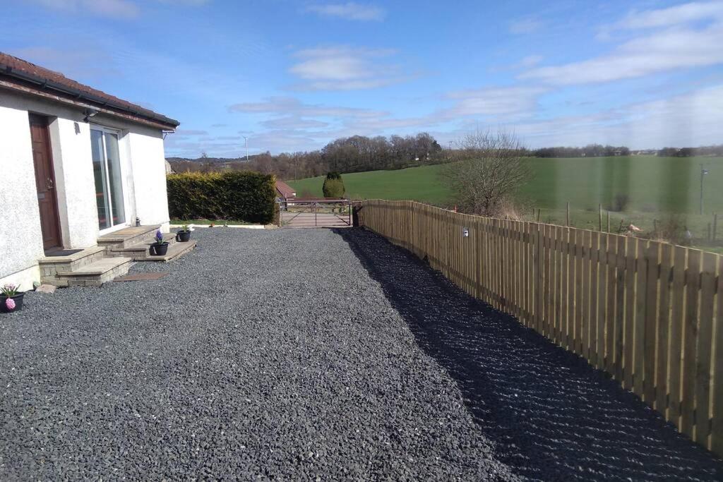 a wooden fence in front of a house at The Cottage - Hot Tub - nr Glasgow - self check-in in Coatbridge