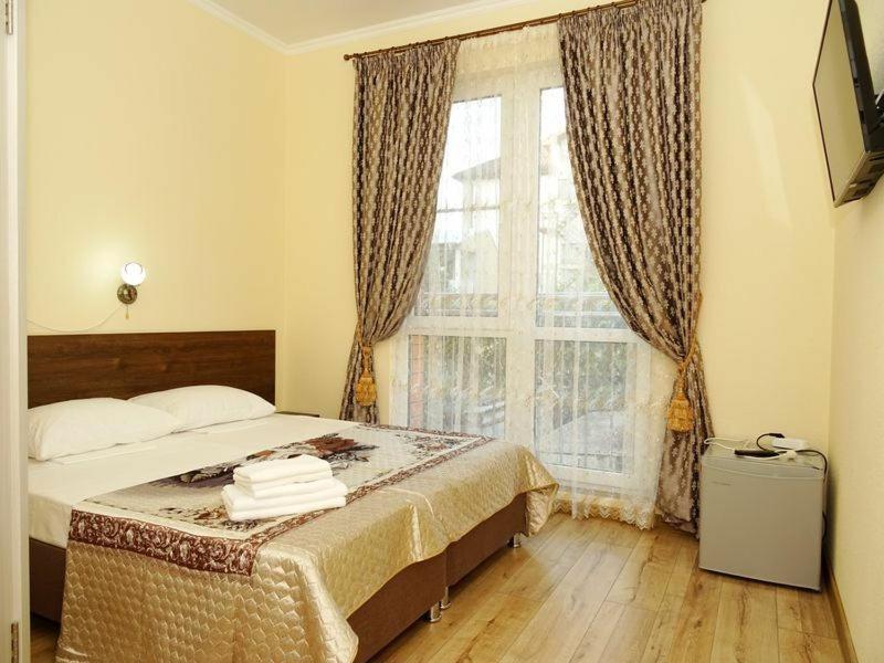 a bedroom with a bed and a large window at Гостевой дом "Дельфин на Черноморской" in Divnomorskoye