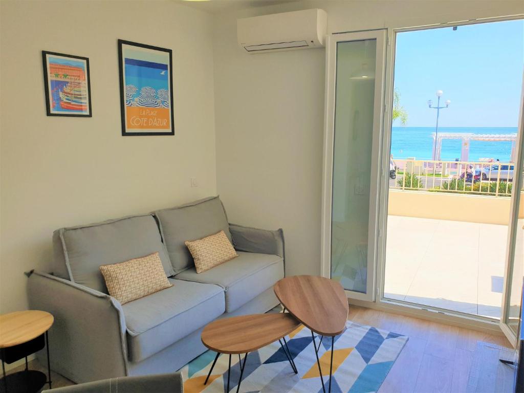 un salon avec un canapé et deux tables dans l'établissement Promenade vue mer, à Nice