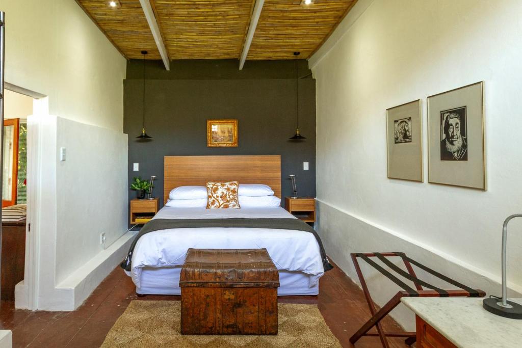 a bedroom with a large bed with a wooden headboard at The Barn On 62 in Montagu