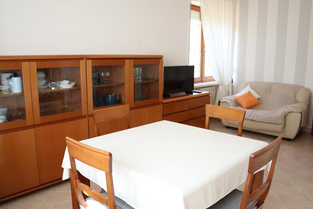 a bedroom with a bed and a living room with a couch at Appartamento L'arancio in Recanati