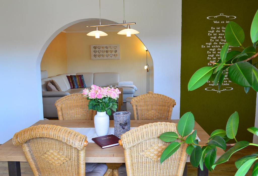 einen Tisch mit Stühlen und eine Vase mit Blumen darauf in der Unterkunft Haus Margarete & Landhaus Karin in Zwiesel