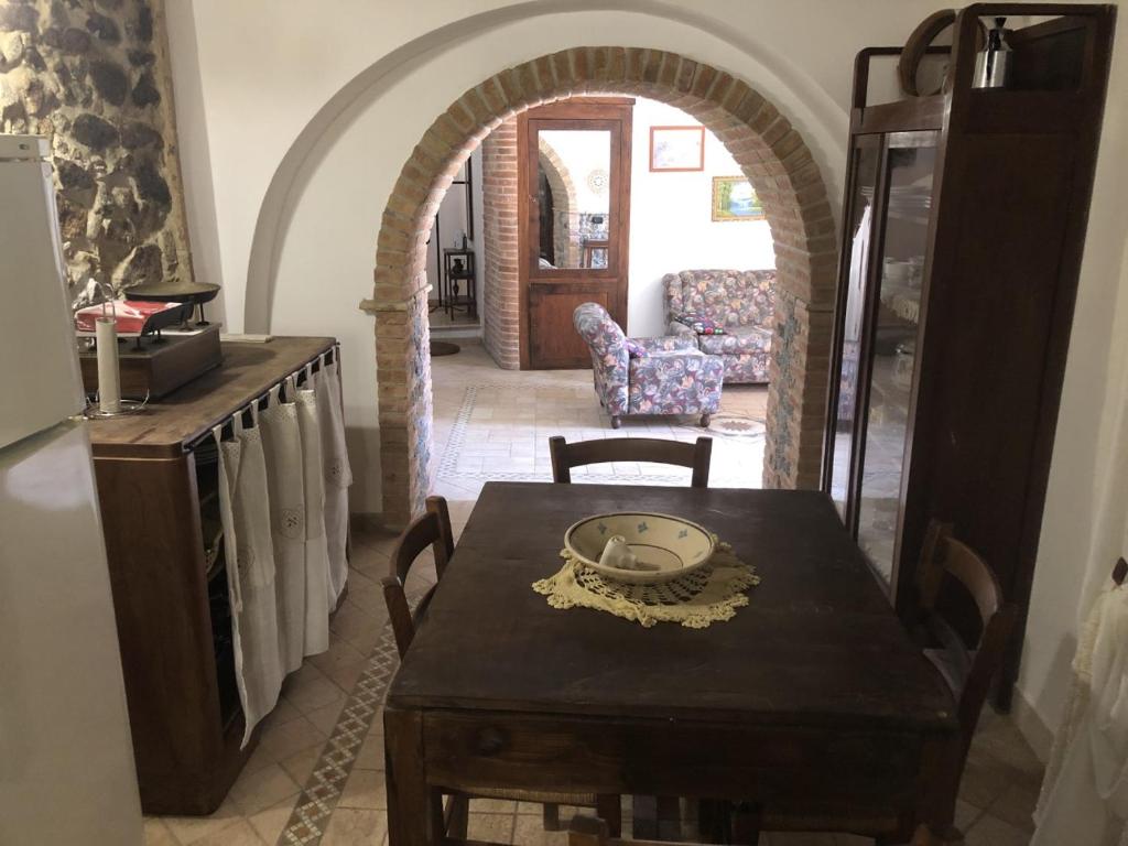 a dining room with a table and chairs and an archway at Casa Vacanze Crocevia in Badolato