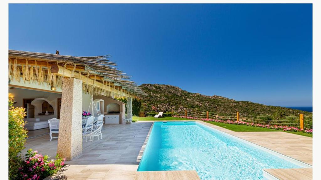 une villa avec une piscine à côté d'une maison dans l'établissement Sardinia Family Villas - Villa MariaPia with private pool and seaview, à Porto Cervo