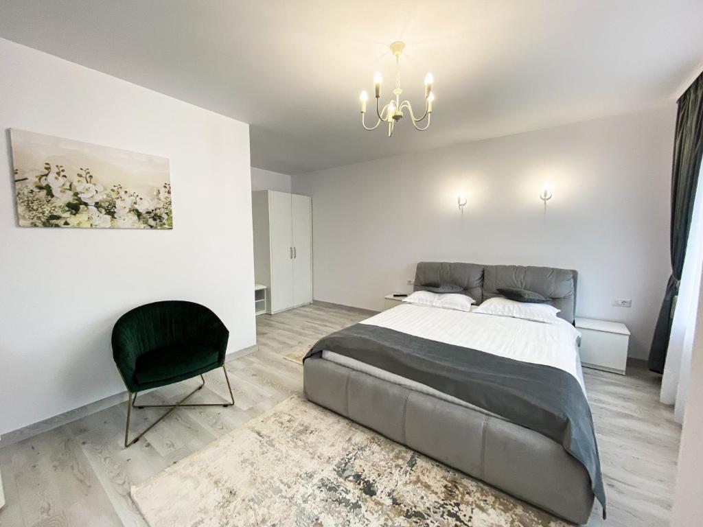 a bedroom with a large bed and a chandelier at Casa Ina in Moisei