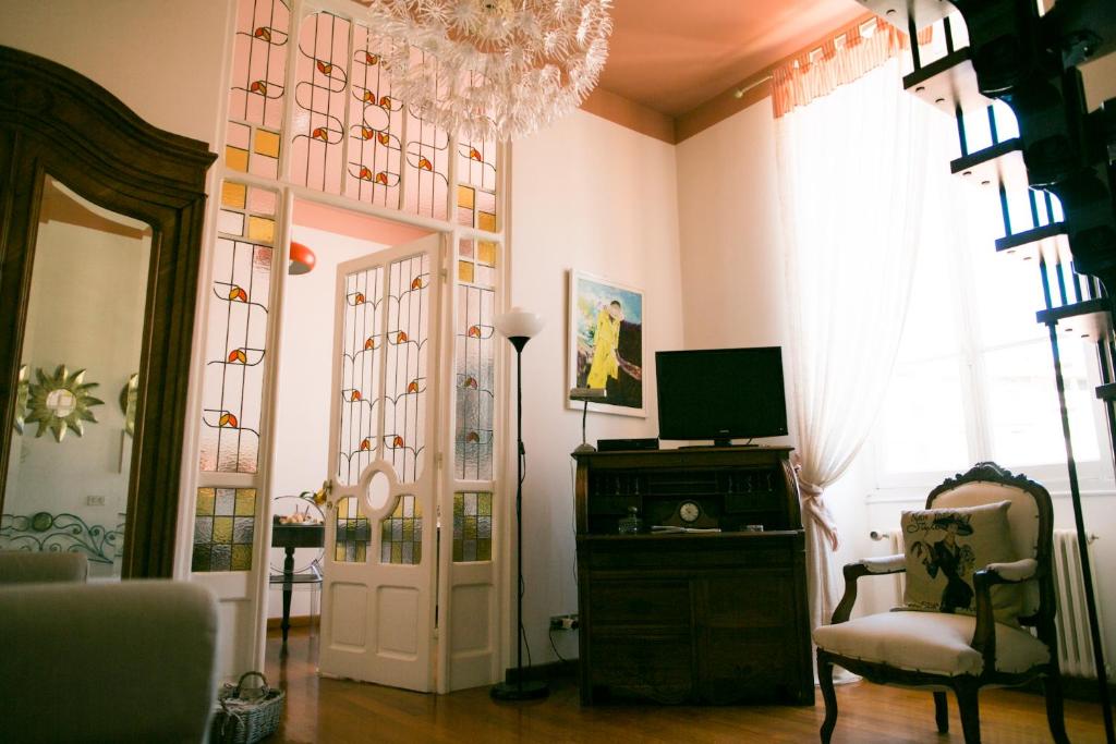 a living room with a chandelier and a door and a chair at B&B Agapantus in una Villa dell'800 in Dolceacqua