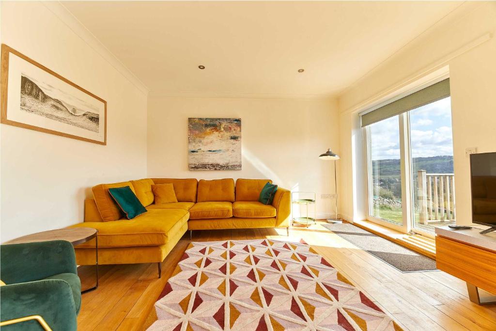 ein Wohnzimmer mit einem Sofa und einem großen Fenster in der Unterkunft Host & Stay - Strathview in Hexham