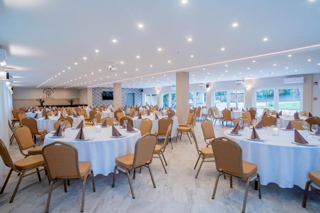 a banquet hall with white tables and chairs at The Hotel Unforgettable - Hotel Tiliana by Homoky Hotels & Spa in Budapest
