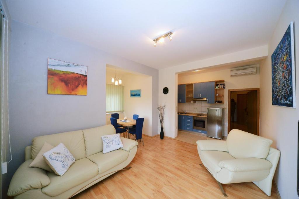 拉布的住宿－Apartments Čule，客厅配有沙发和两把椅子