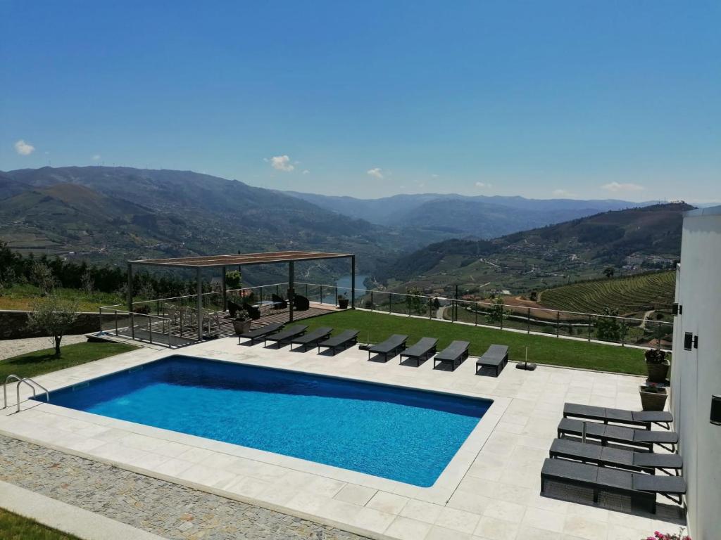 a swimming pool with chairs and a view of mountains at Casa Miradouro in Mesão Frio