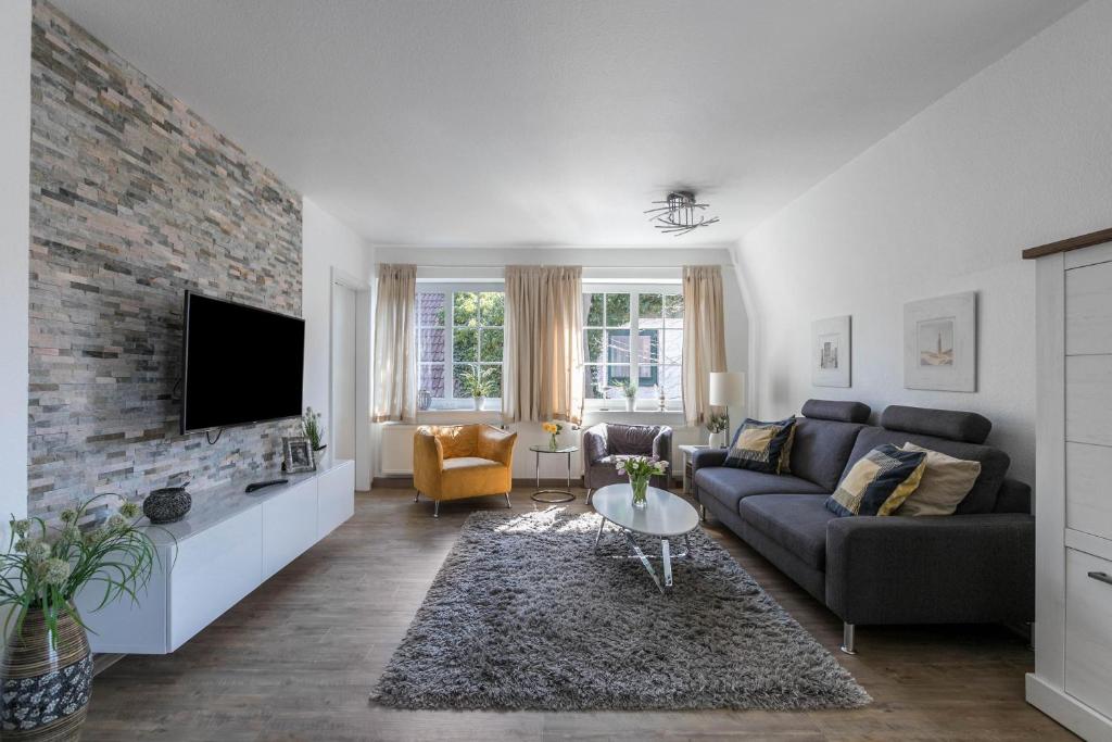 ein Wohnzimmer mit einer Couch und einer Ziegelwand in der Unterkunft Ferienwohnung Kille-rechte Wohnung in Sankt Peter-Ording