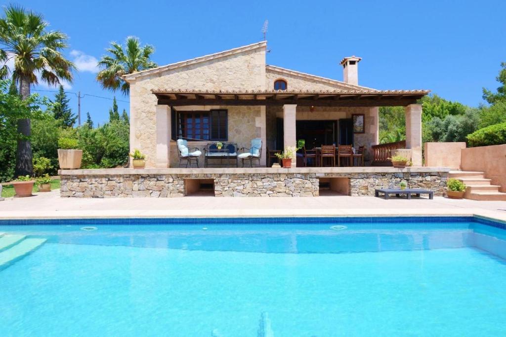 a villa with a swimming pool in front of a house at Sa Vinyeta de Son Jaumell in Capdepera