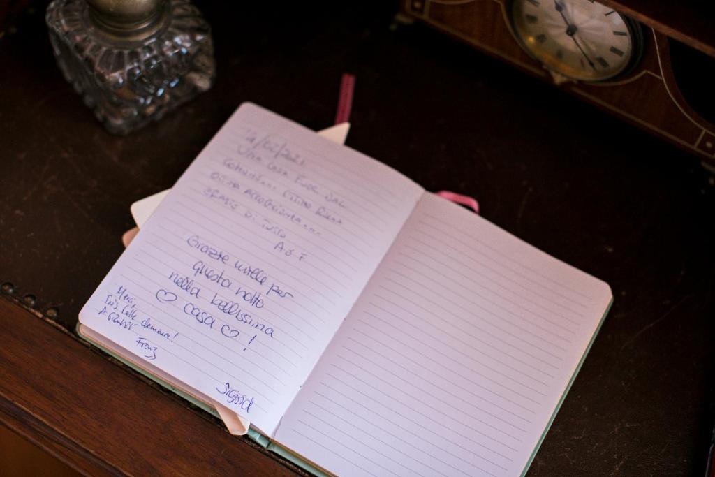 a notebook with writing on it on a table at B&B Agapantus in una Villa dell'800 in Dolceacqua