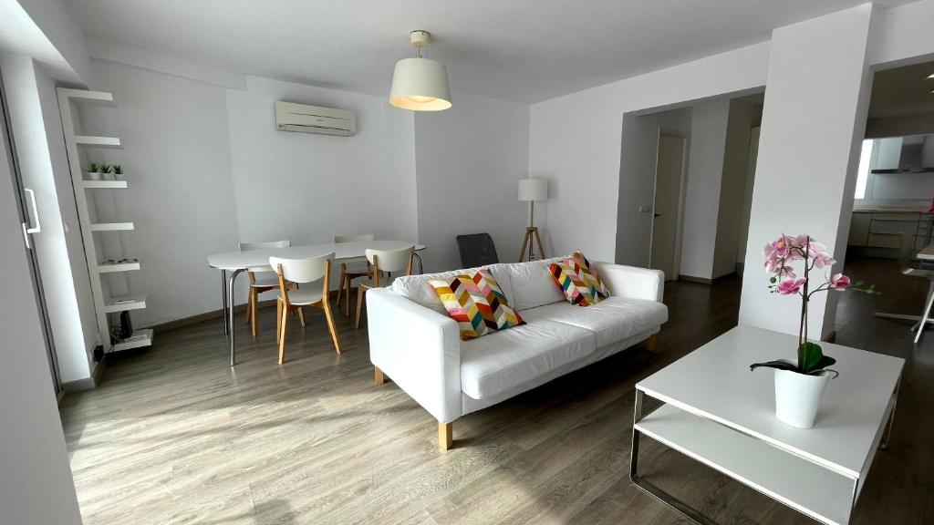 a living room with a white couch and a table at Pollensa Beach Loft in Port de Pollensa