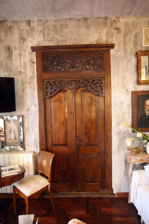 duże drewniane drzwi w salonie z kanapą w obiekcie Accardi House Searooms w mieście Palermo