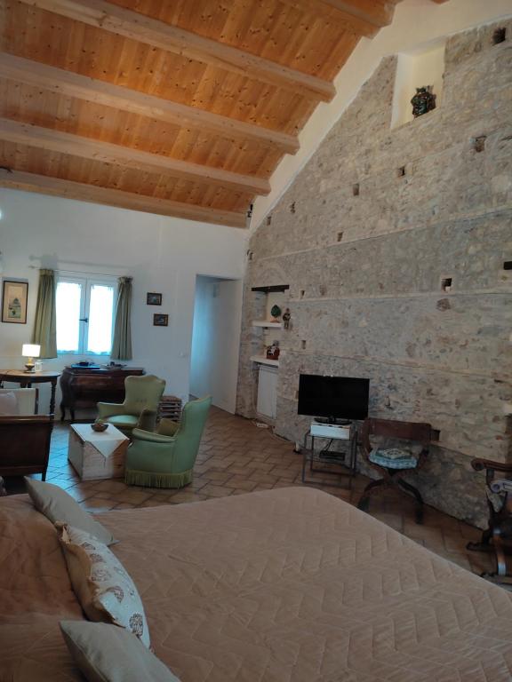 una gran sala de estar con una pared de piedra. en Rosa Thea Suite, en Taormina