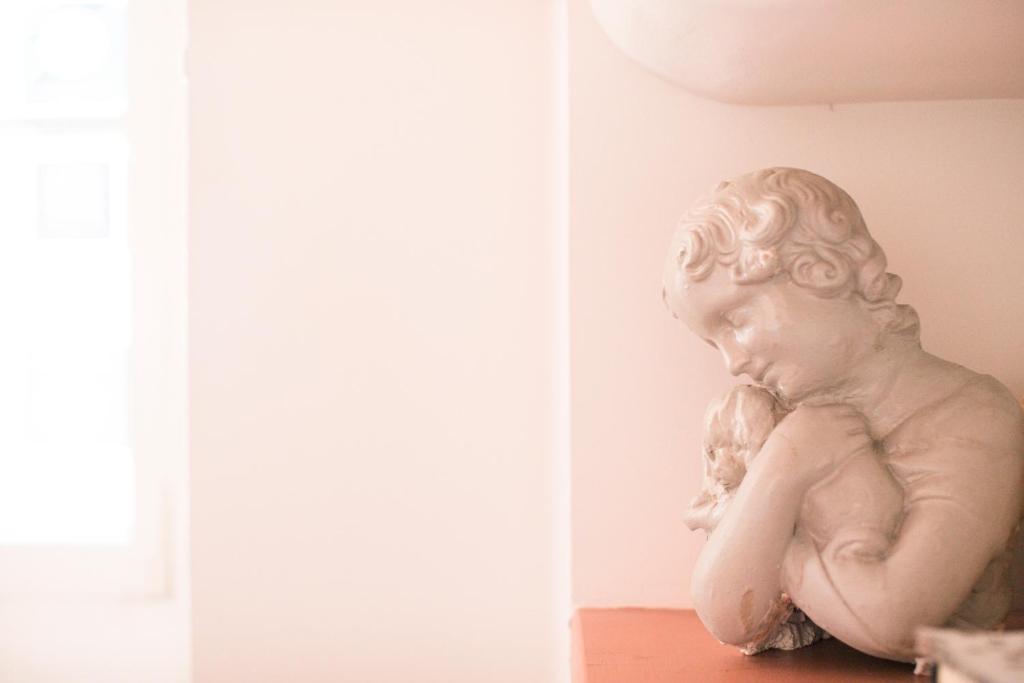 a statue of a cherub sitting on a table at B&B Agapantus in una Villa dell'800 in Dolceacqua