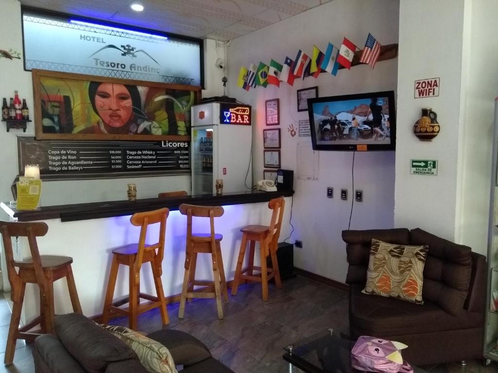 a bar in a room with chairs and a tv at Tesoro Andino in La Tebaida